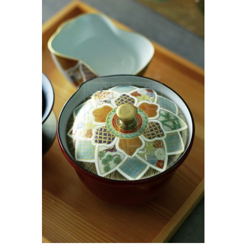 Japanese hōhin teapot on a rustic table setting, representing harmony of tea and sake traditions