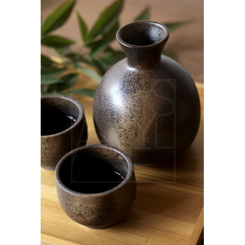 A handmade sake cup with warm, earthy texture, used for serving Japanese sake.